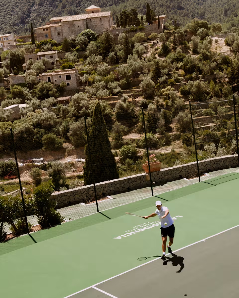 Belmond La Residencia 網球場，背景為 Sant Joan de Deià 教堂